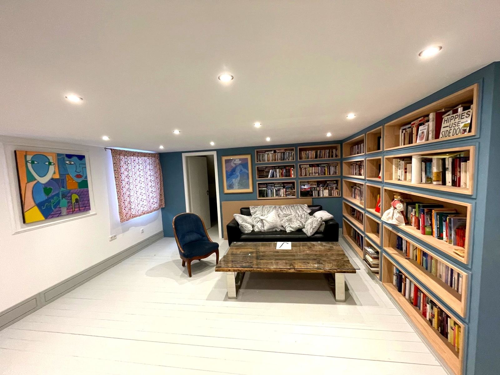 Großes Zimmer mit Bücherwand, Sofa und Mediathek